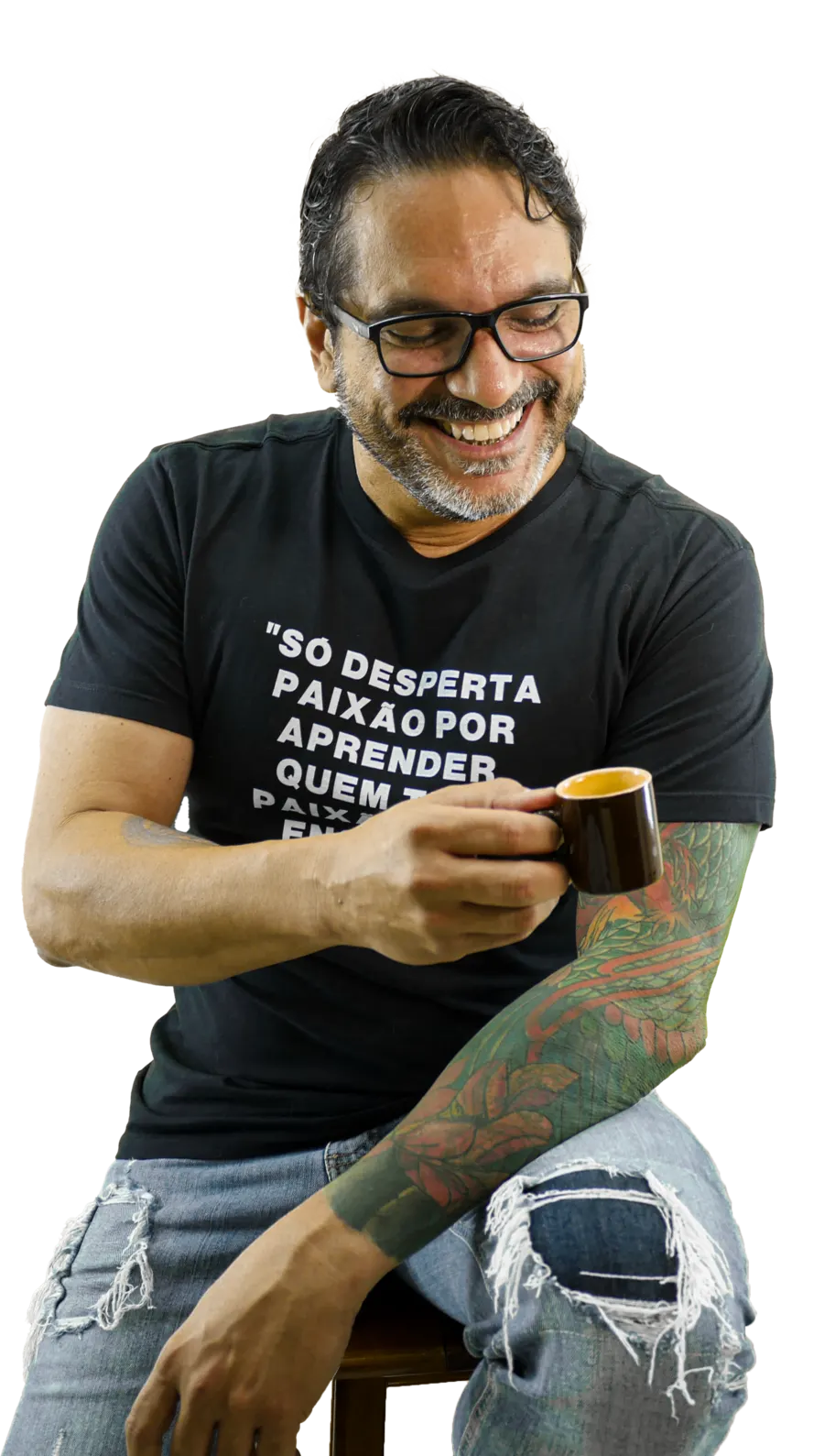 Professor Fragale sentado, sorrindo, segurando uma xícara de café